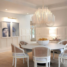 CERYNE - White wood chandelier above a round kitchen table