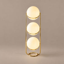 ORVENA three-tier brass globe floor lamp on a mushroom taupe background