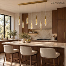 RAIN DROPS 7-light rectangular gold chandelier above a walnut and quartzite kitchen island with three upholstered stools; photorealistic installation visualization.