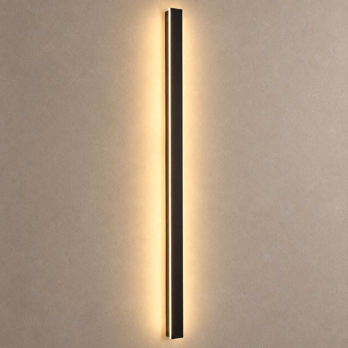 RAYN slim black wall light mounted on mushroom taupe plaster with warm backlight and natural shadows