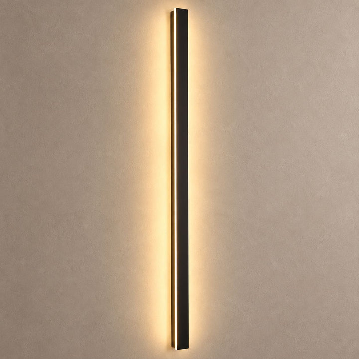 RAYN slim black wall light mounted on mushroom taupe plaster with warm backlight and natural shadows