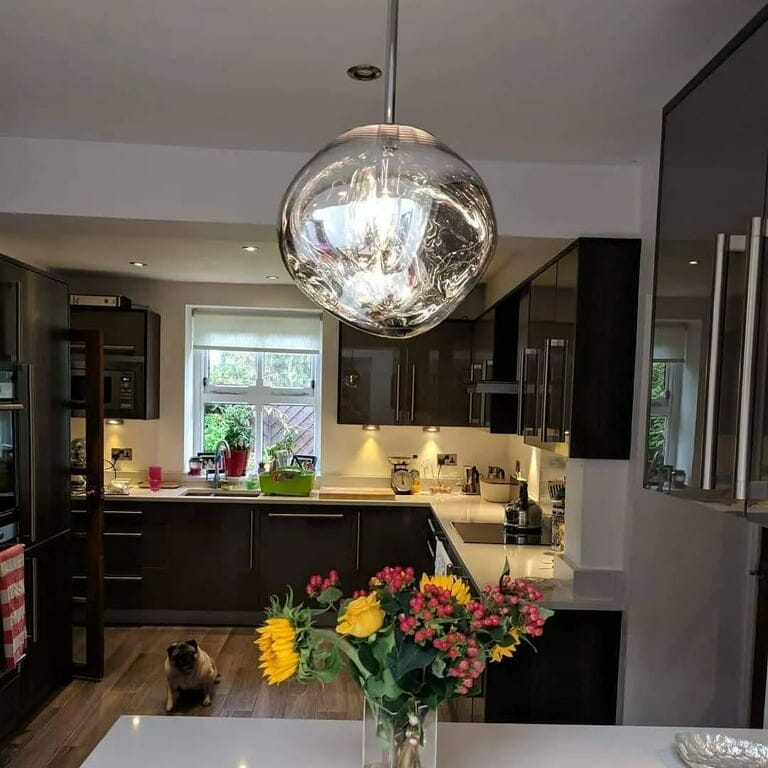 LAVA single large silver mirrored pendant in a kitchen with dark cabinets