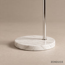 Close-up of SILENNA circular white marble base and offset polished steel stem