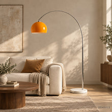 SILENNA orange arc floor lamp visualized beside an ivory sofa in a warm living room