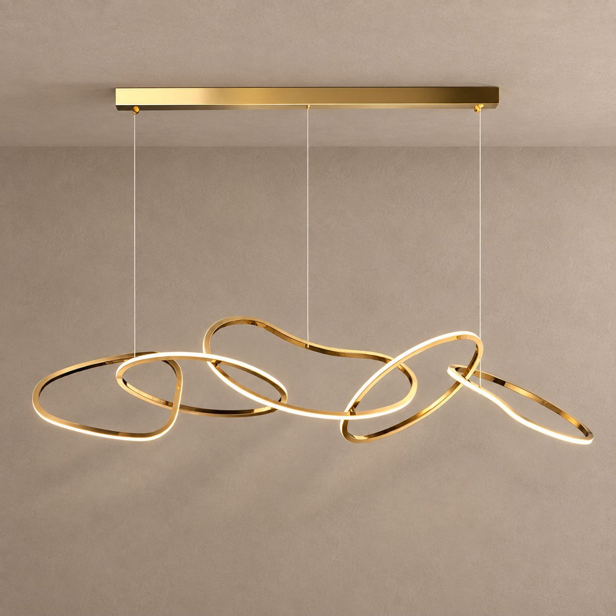 SOLARA gold chandelier with five interlinked organic LED loops against mushroom taupe plaster