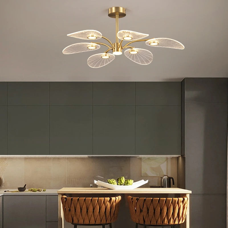 ORVIAN petal ceiling light, lit, above a kitchen island with woven stools