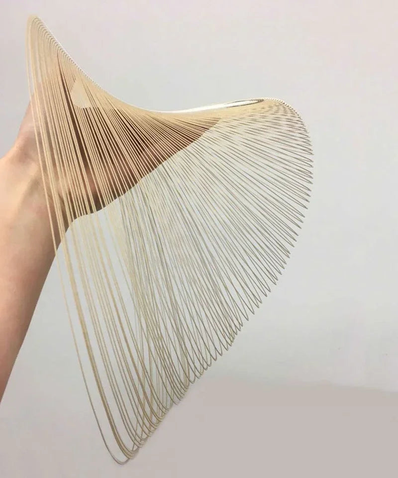 LUCORA wood-strip shade held by hand, showing its curved ribbed form