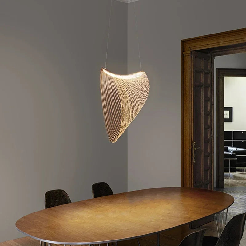 LUCORA wood-strip pendant light, lit, above an oval dining table