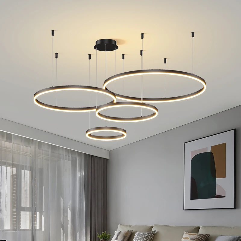 CIRCLETS four black LED rings, lit, at staggered heights in a living room by a window