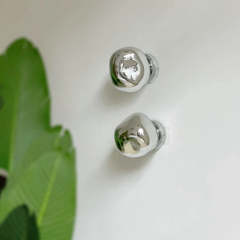 LAVA WALL pair of chrome acrylic wall lights on a white wall, unlit