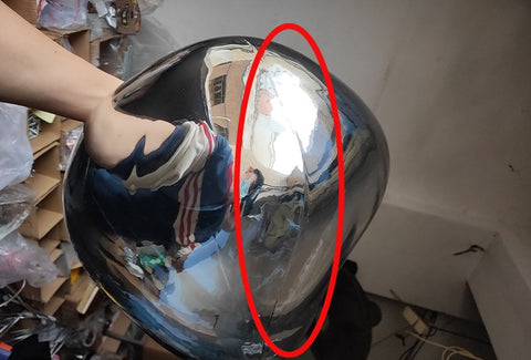 LAVA DROPS hand holding a silver mirrored shade, with an area circled in red for detail