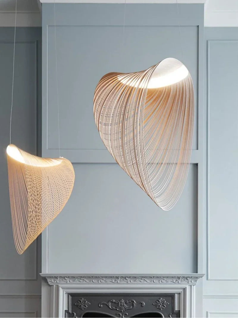 LUCORA two curved wood-strip pendant lights, lit, in a room with blue walls